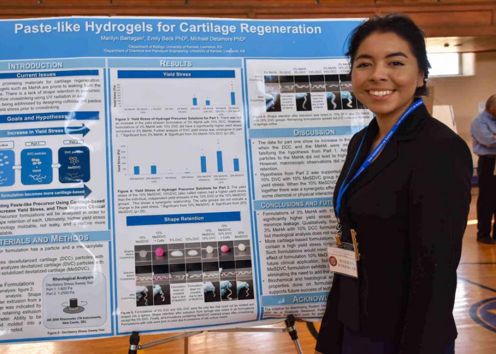 Student presenter with their poster at the KU/Haskell Undergraduate Research Symposium